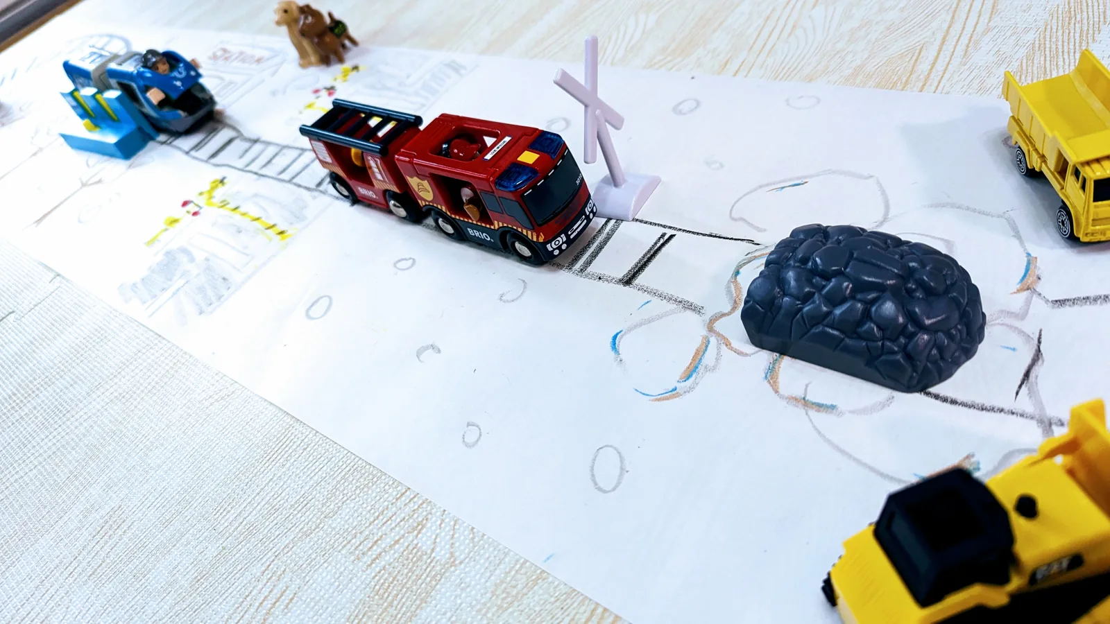 せんろや道路のイラストを書き、トミカやブリオといったおもちゃを集結させます。